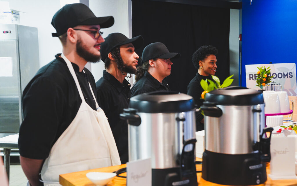 Four Staff Members in Aprons Standing in a Line