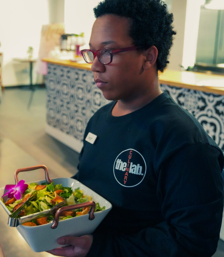 Culinary Lab Waitress with Glasses Holding Plate of Food